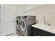 Functional laundry room with a modern washer and dryer, storage shelf, and utility sink with sleek faucet at 13789 Old Creek Ct, Parrish, FL 34219