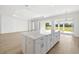 Kitchen island with white cabinets and light wood floors at 15508 San Lazzaro Avenue, Bradenton, FL 34211