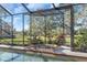 Relaxing screened-in pool and spa with a beautiful view of the lush green backyard at 3113 Lakeside Cir, Parrish, FL 34219