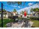 Outdoor picnic area with gas grill, table, umbrella, and lush greenery at 3255 Beneva Rd # 103, Sarasota, FL 34232