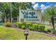 Well-manicured sign for the Village Brooke Condominiums with lush landscaping at 3255 Beneva Rd # 103, Sarasota, FL 34232