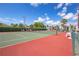 Outdoor tennis court with green and red surface within a condominium community at 3255 Beneva Rd # 103, Sarasota, FL 34232