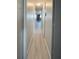 Long hallway with light walls and wood-look flooring at 3334 Overcup Oak Ter, Sarasota, FL 34237