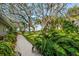 A brick pathway surrounded by lush tropical plants leads to the waterfront at 3350 Old Oak Dr, Sarasota, FL 34239