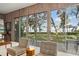 Bright living room featuring wood-paneled walls and large windows offering beautiful outdoor and water views at 3350 Old Oak Dr, Sarasota, FL 34239