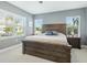 Main bedroom with wood bed frame and large windows at 3450 77Th W St # 102, Bradenton, FL 34209