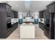 Modern kitchen with dark cabinetry, large island, and stainless steel appliances at 3479 Knox Ter, Port Charlotte, FL 33948