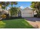 Tan house with a three-car garage and lush landscaping at 3614 Summerwind Cir, Bradenton, FL 34209