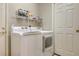 Functional laundry room with washer, dryer, and shelving for storage at 4226 Fairway Pl, North Port, FL 34287