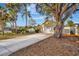 House's exterior features a driveway, large tree, and fenced yard at 5101 Island Date St, Sarasota, FL 34232