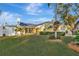 Well-maintained yellow house with a green lawn, a white fence, and a red front door at 5101 Island Date St, Sarasota, FL 34232
