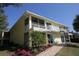 Bright yellow building with walkway, landscaping, and ocean view at 5311 Gulf Of Mexico Dr # 6, Longboat Key, FL 34228