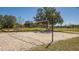 Community sand volleyball court in a grassy, landscaped common area with mature trees in the background at 6476 Royal Tern Cir, Lakewood Ranch, FL 34202