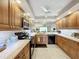 Modern kitchen with wood cabinets, granite counters, and stainless steel appliances at 6609 Stone River Rd # 104, Bradenton, FL 34203