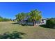 Landscaped backyard with lush grass and mature palm trees at 6629 Pleasant Hill Rd, Bradenton, FL 34203