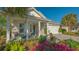 Charming front porch features a sitting area, lush landscaping, and a blue door at 899 Seascape Pl, Sarasota, FL 34240