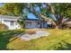 Backyard with a large oak tree, fire pit area, and green grass at 911 42Nd W St, Bradenton, FL 34205