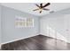 Bright bedroom with dark wood-look floors, ceiling fan, large window, and closet at 911 42Nd W St, Bradenton, FL 34205