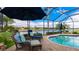 Peaceful pool and patio with wicker furniture and lake view at 1342 Calais Cir, North Venice, FL 34275