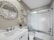 Modern bathroom featuring a white vanity with marble countertop, glass shower door, and decorative mirror at 2215 Harbourside Dr # 304, Longboat Key, FL 34228