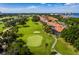 Aerial view of the golf course with a townhome community along the edge and water views at 2215 Harbourside Dr # 304, Longboat Key, FL 34228