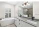 Modern bathroom with double vanity, grey countertop, and free standing tub at 224 Corelli Dr, Nokomis, FL 34275