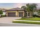 Beautiful two-story home with a three-car garage and a manicured lawn at 224 Corelli Dr, Nokomis, FL 34275