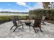Relaxing fire pit area with seating overlooking a lake at 224 Corelli Dr, Nokomis, FL 34275