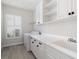 Bright laundry room with white cabinets and tile floor at 224 Corelli Dr, Nokomis, FL 34275