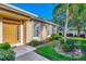 Inviting front yard with a walkway leading to the golden front door, lush landscaping, and palm trees at 2520 Terracina Dr, Venice, FL 34292
