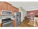 Kitchen featuring stainless steel appliances, wood cabinetry, and tile backsplash at 2520 Terracina Dr, Venice, FL 34292
