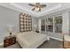 Main bedroom with ceiling fan, plush carpeting, and large window with natural light at 2520 Terracina Dr, Venice, FL 34292