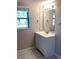 Simple bathroom with white vanity, mirror, and window at 2766 Heather Pl, Sarasota, FL 34235