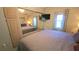 Bedroom featuring a queen-size bed, wall-mounted TV, mirrored closet doors, and large windows at 3333 26Th E Ave # 1107, Bradenton, FL 34208