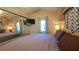 Bedroom with a queen-size bed, mirrored closet doors, a wall-mounted TV, and patterned curtains at 3333 26Th E Ave # 1107, Bradenton, FL 34208