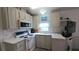 Kitchen with white appliances, light green cabinets, and a flat-screen TV at 3333 26Th E Ave # 1107, Bradenton, FL 34208