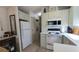 Kitchen with white appliances, light green cabinets, and a stacked washer/dryer at 3333 26Th E Ave # 1107, Bradenton, FL 34208