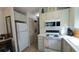 Compact kitchen with white appliances, light green cabinets, and a stacked washer and dryer at 3333 26Th E Ave # 1107, Bradenton, FL 34208