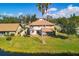 Aerial view of the back of the home, a pond, and mature palm trees on a sunny day at 3468 51St Avenue W Dr, Bradenton, FL 34210
