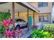 Stylish home with a covered carport featuring a vibrant blue front door and beautiful, colorful landscaping at 3468 51St Avenue W Dr, Bradenton, FL 34210