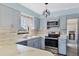 Modern kitchen featuring gray cabinets, stainless steel appliances, stylish lighting, and bright countertops at 3468 51St Avenue W Dr, Bradenton, FL 34210