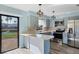 Open kitchen featuring modern appliances, stylish lighting, light countertops and sliding glass doors at 3468 51St Avenue W Dr, Bradenton, FL 34210