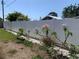 Landscaped backyard with mature flowering trees and white vinyl fence at 4001 17Th W Ave, Bradenton, FL 34205