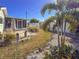 Landscaped backyard with palm trees, tiki torches, brick pavers, a white fence, and a screened-in lanai at 4001 17Th W Ave, Bradenton, FL 34205