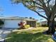 Front exterior of a single-story home with attached garage, landscaping, and large tree at 4339 Bowling Green Cir # 19, Sarasota, FL 34233