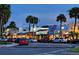 Evening street view of a bustling commercial area with shops, palm trees, and parked cars at 451 Bowdoin Cir, Sarasota, FL 34236