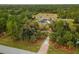 High-angle view of the property showing lush landscaping, driveway, and surrounding trees at 5105 Bannock Cir, North Port, FL 34288