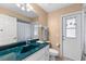 Bathroom with teal countertop, white cabinets, and access to the pool area at 5105 Bannock Cir, North Port, FL 34288