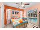 Bedroom with pool view featuring orange walls, ceiling fan, and coastal decor at 5105 Bannock Cir, North Port, FL 34288