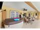 Hot tub in a screened-in patio area, with dining table and chairs and refrigerator at 5105 Bannock Cir, North Port, FL 34288